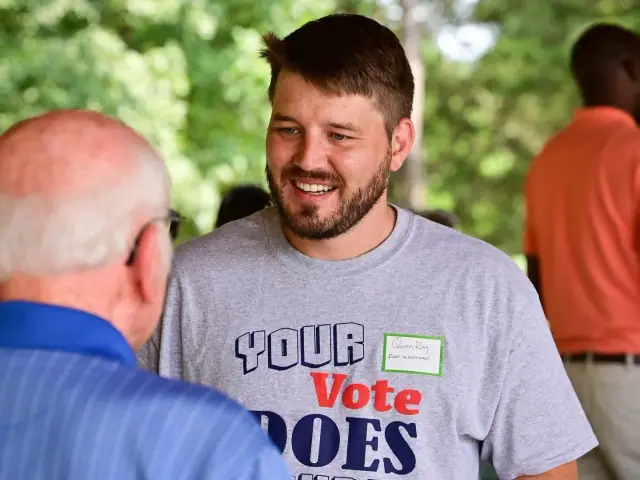 Quinn Ray speaking with neighbors at a community event